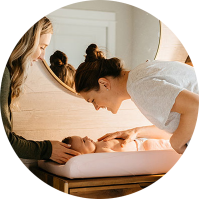 Two young women changing a baby's diaper.