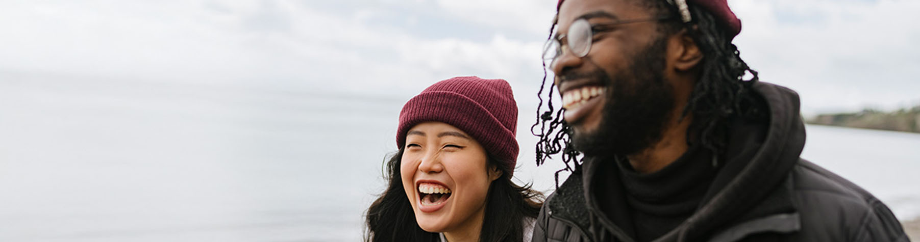 A young couple walking along the ocean, in the winter time