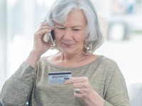Senior woman on phone with credit card