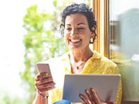 Woman working on phone and tablet