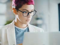 Young woman with pink hair on a laptop