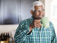 Confident man sipping coffee from a mug in his kitchen